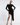 Woman in a black long sleeve dress with asymmetrical hem and neckline