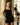 Woman in a black dress standing in a room with decorative elements.