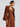 Woman in a brown suit blazer with. matching corset and trouser