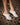 woman's lower leg wearing white heels on a tile floor